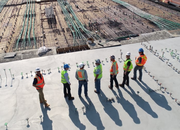 Vue aérienne d'une équipe de chantier en gilets de sécurité sur une dalle en construction